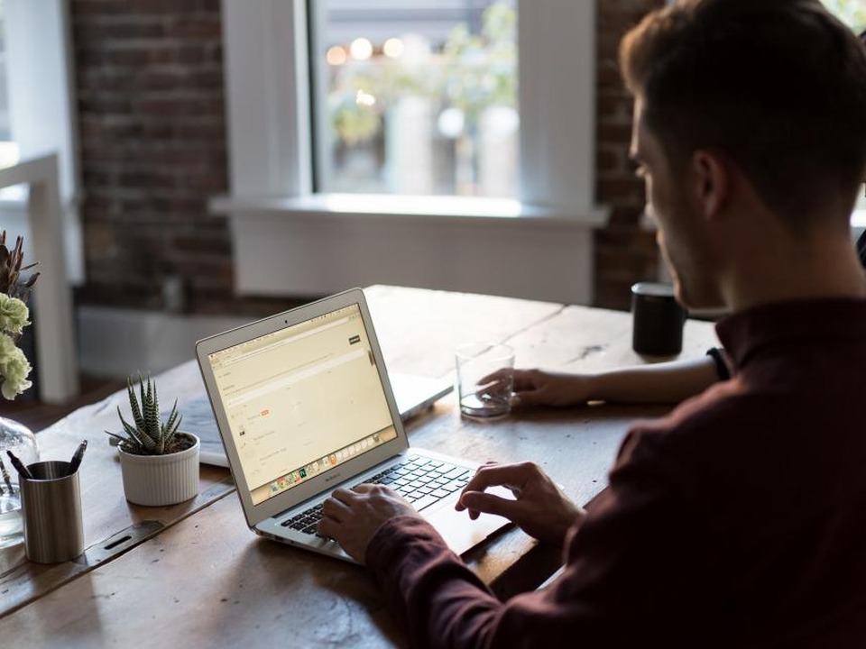 A student working on a laptop at a bright desk